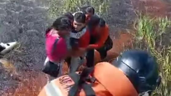 Rescuers pulling survivors from swamp after plane crash.