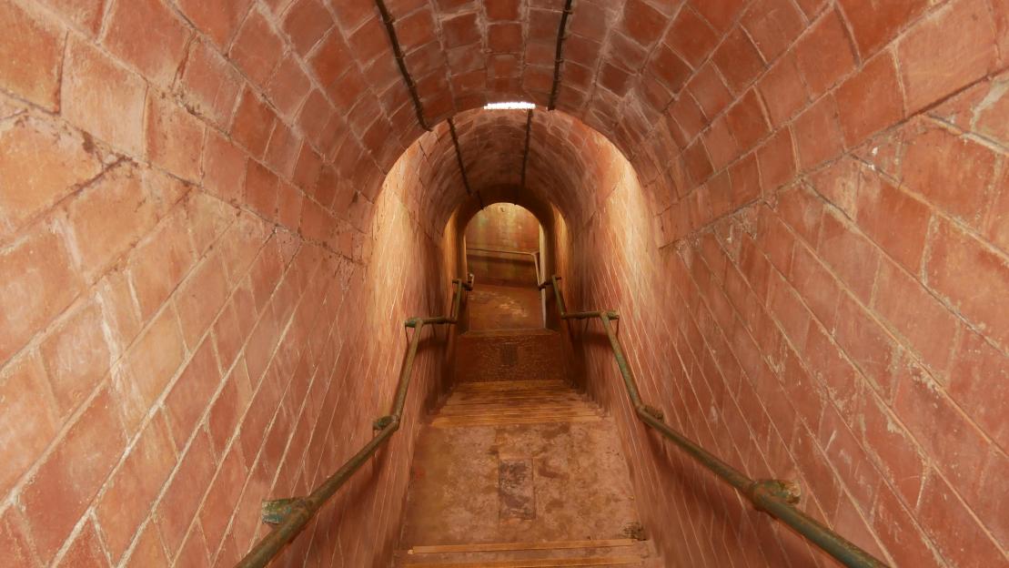 Brick tunnel stairs leading down to a beach.