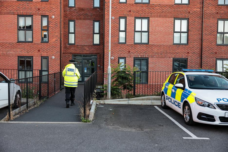 A police officer stands guard outside a block of flats where a missing seventeen-year-old girl's body was found.