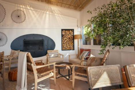 Relaxing lounge area with fireplace and wicker chairs.