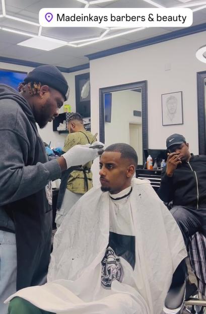 Alexander Isak receiving a haircut from a barber at "Madeinkays barbers & beauty."