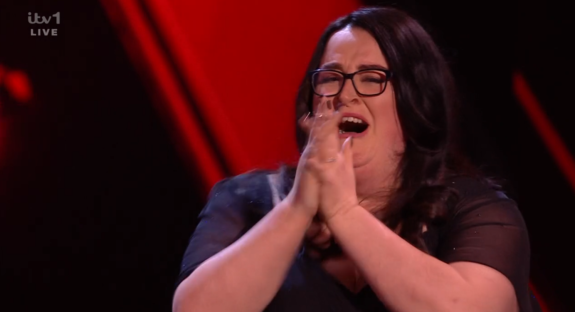 Screenshot of a woman crying and clapping her hands.
