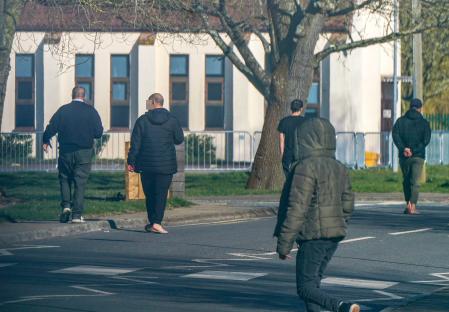 Migrants walking near a building.