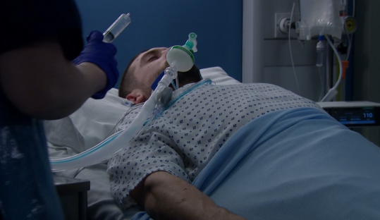 A patient lying in a hospital bed receiving medical treatment.