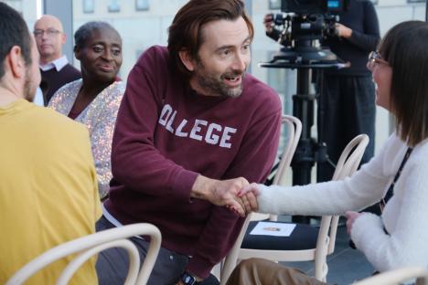 David Tennant shaking hands with a woman during an interview.