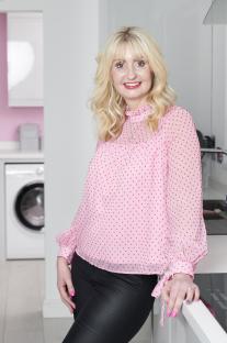 Lynsey Crombie leaning on a kitchen counter.