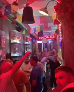 Crowded bar with people celebrating.