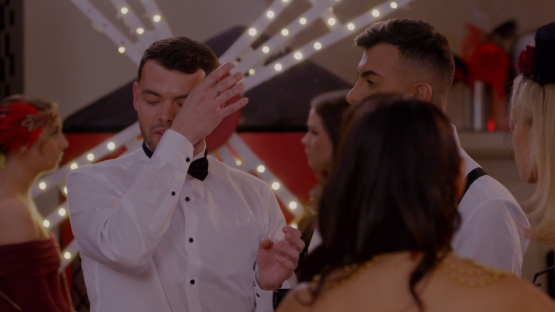Man wiping his eyes at an emotional event.
