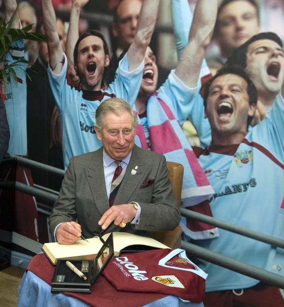 Prince Charles signing a visitor's book at Burnley Football Club.