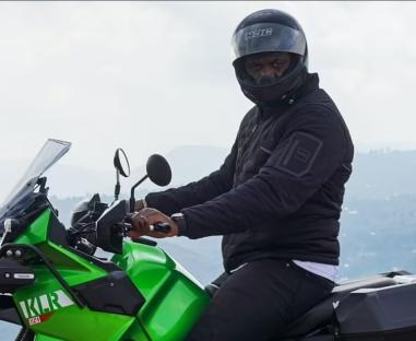 Francis Ngannou on a green motorcycle.