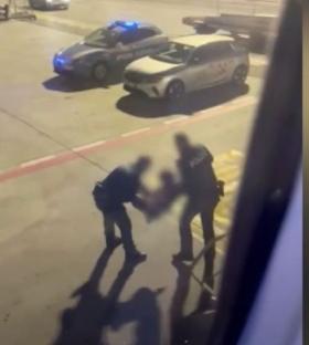 Police removing disruptive passengers at an airport.