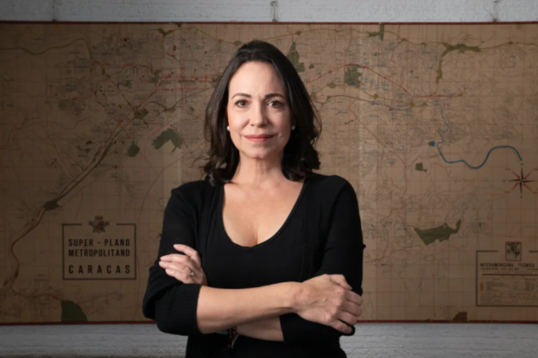 A woman with dark hair in a black top standing in front of a vintage map.