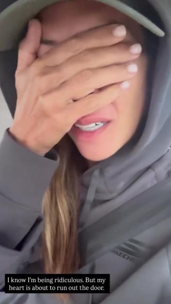 Myleene Klass crying, covering her face with her hand.