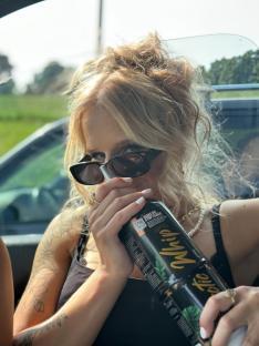 Woman inhaling nitrous oxide from a canister.