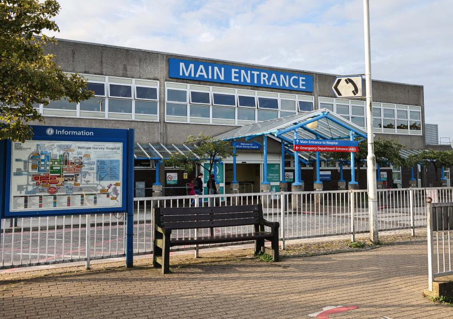 Exterior view of William Harvey Hospital in Ashford, Kent, with a "MAIN ENTRANCE" sign.