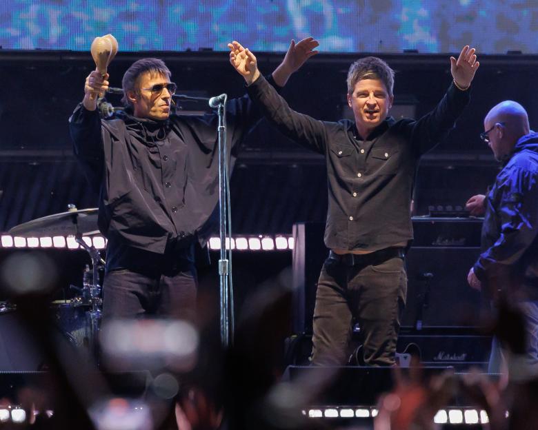 Liam Gallagher and Noel Gallagher of Oasis performing onstage.