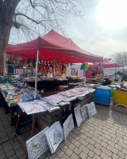 Market stall selling toys and coloring pages.