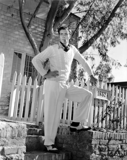 Black and white photo of Frank Shields, American actor and tennis player, outside his house.