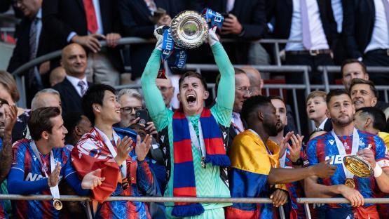 Dean Henderson of Crystal Palace holding up the Emirates FA Cup trophy.
