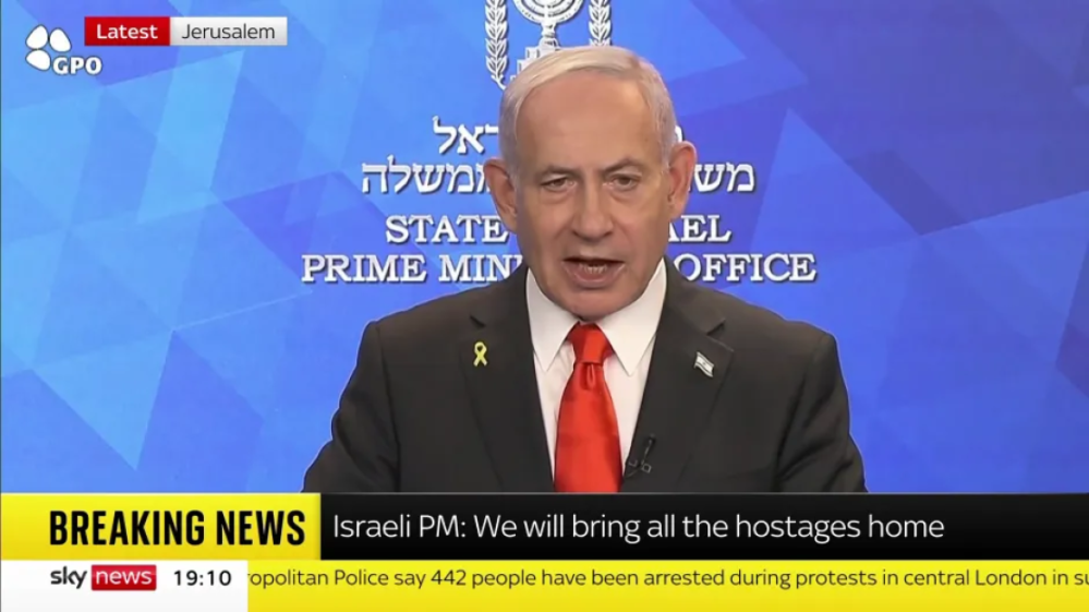 Israeli PM Benjamin Netanyahu speaking, with a "BREAKING NEWS" banner stating "Israeli PM: We will bring all the hostages home."