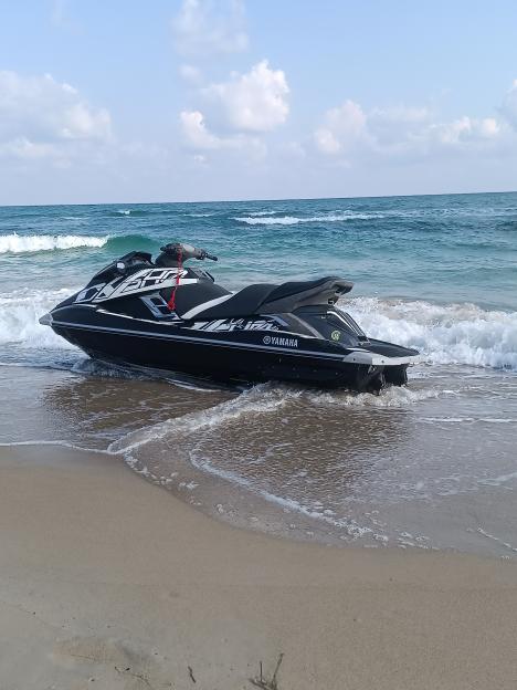 Black jet ski beached at the edge of the ocean.