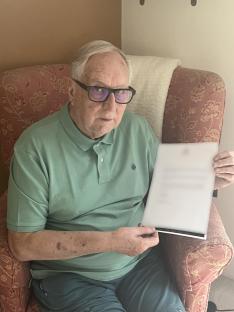 A man holds a document explaining that his cruise was cancelled due to post-Brexit passport rules.