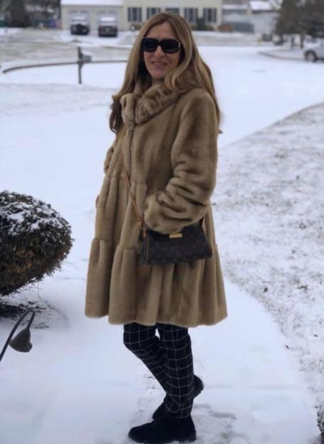 a woman in a fur coat is standing in the snow