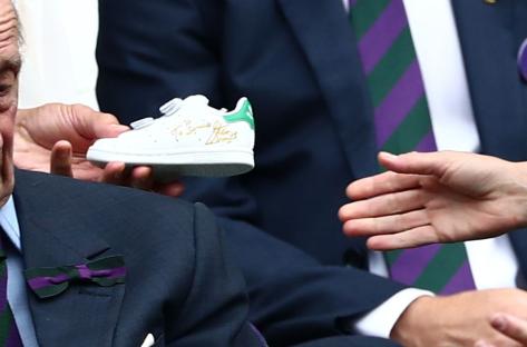 A signed Adidas Stan Smith trainer being given to Prince Louis.