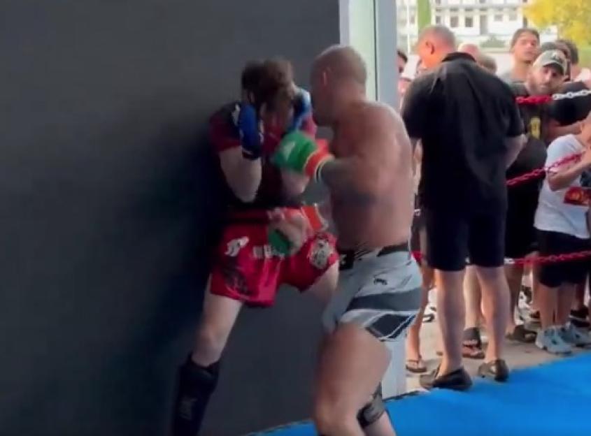 Two martial artists sparring near a wall.