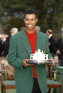 Tiger Woods wearing a green jacket and holding the Masters Tournament trophy.