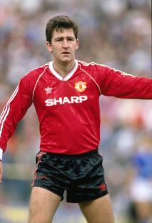 Norman Whiteside of Manchester United in a red jersey.