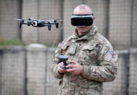 A British soldier wearing a VR headset operates a drone.
