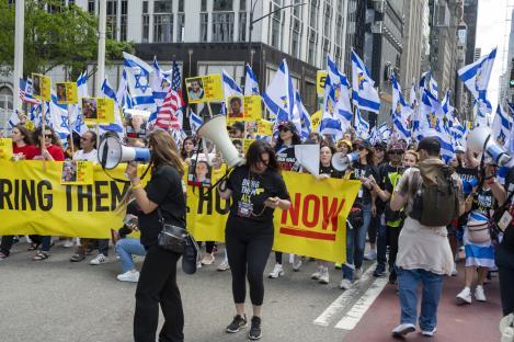 Marchers at the Israel Day Parade carry signs demanding the release of hostages.