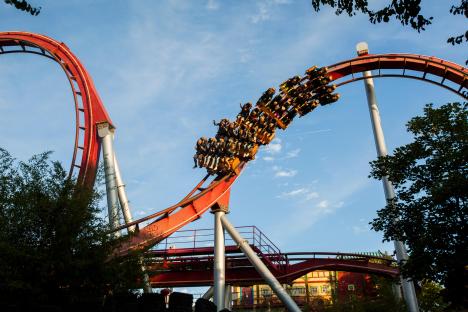 Rollercoaster riders soaring through a loop.