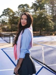 Woman in tennis attire on a tennis court.