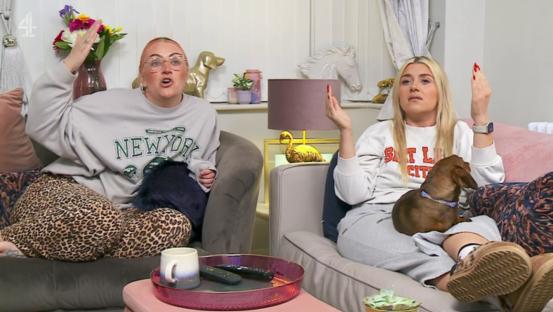 Two women sitting on a couch, reacting angrily.