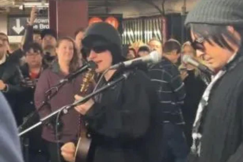 Huge Brit pop star looks unrecognisable in disguise as he plays subway station – but can you tell who it is?