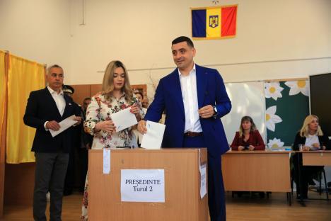 A man in a blue suit casting a ballot in a Romanian presidential election.