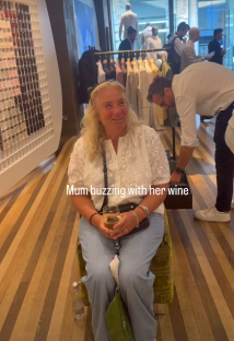 Woman sitting and enjoying wine in a clothing store.