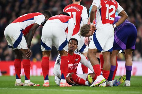 Arsenal's Gabriel injured on the pitch, consoled by teammates.