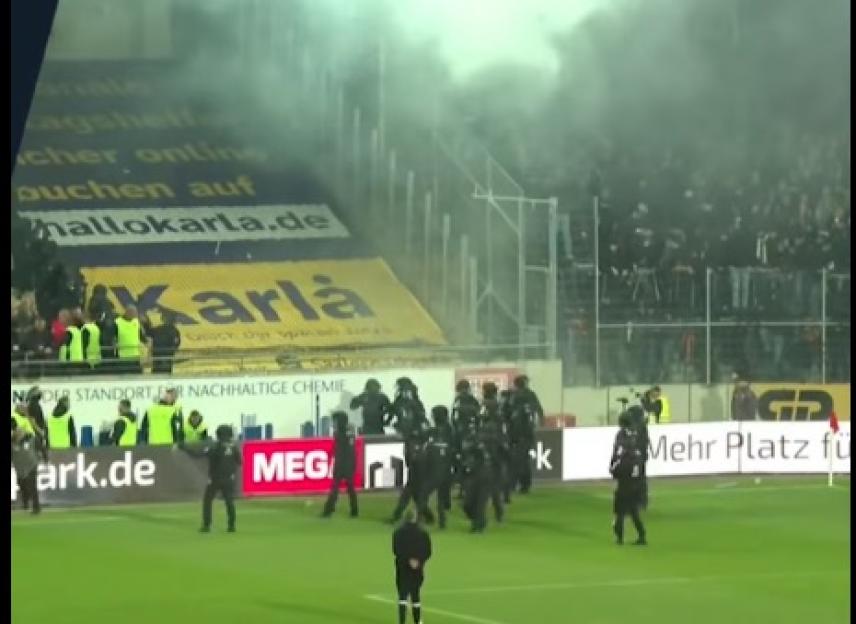 Riot police responding to smoke at a soccer game.