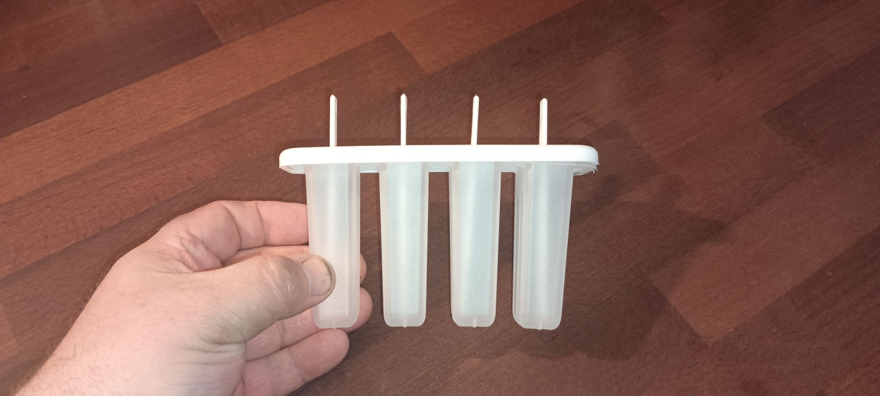 Hand holding a four-cavity ice pop mold.