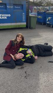 Craig and Maria on the ground; a police officer is injured.