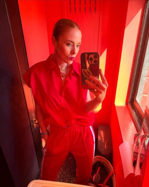 Angela Scanlon in a red outfit taking a selfie.