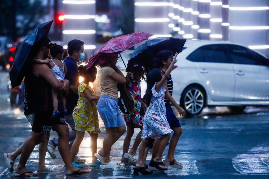 People with umbrellas walk through heavy rains and strong winds from Super Typhoon Ragasa in Metro Manila, Philippines.