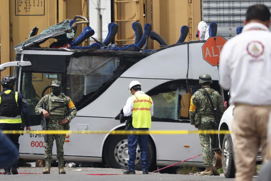Soldiers and rescue personnel at the scene of a train and bus accident.