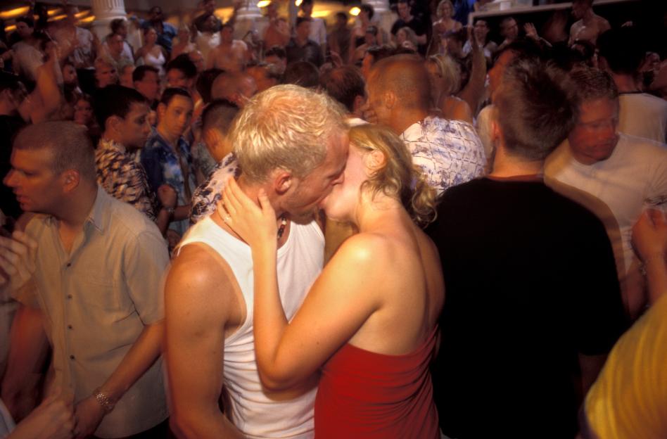 Couple kissing at a party.