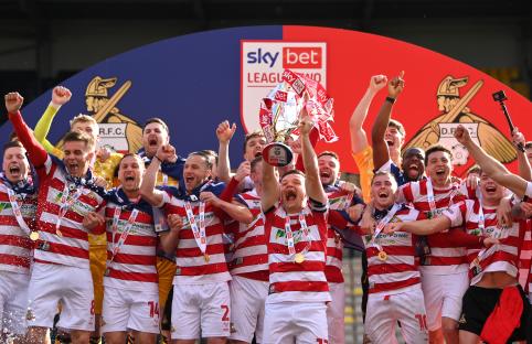 Doncaster Rovers team celebrating their Sky Bet League Two Championship win.
