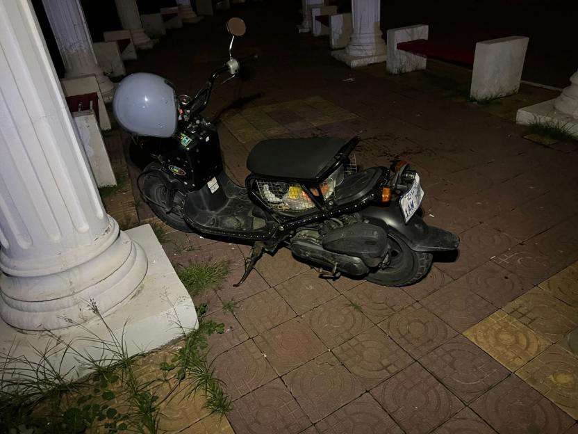 Scooter parked at night near a crime scene.