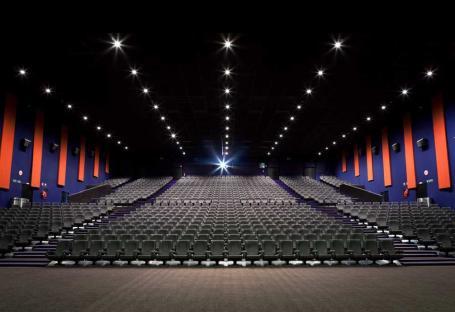 Large movie theater auditorium with many empty seats.